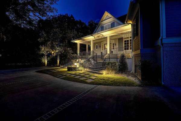 Warmly lit home porch at dusk in a residential neighborhood